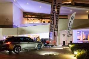 Evento de presentación corporativa de BMW en un espacio exterior con vehículos y elementos de marca visibles.