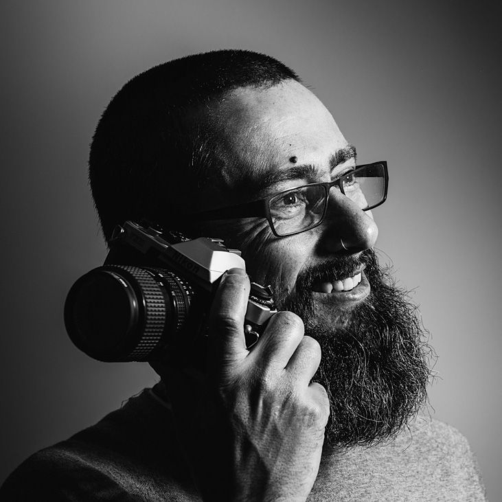 Raúl Mellado, fotógrafo para empresas en Barcelona, simulando una llamada con una cámara.
