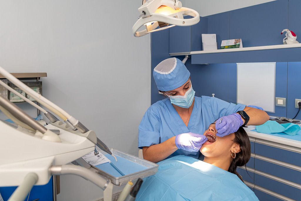 Profesional atendiendo a una paciente simulada en una consulta dental.
