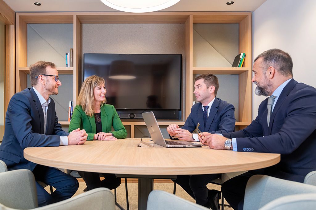 Equipo reunido en un entorno corporativo durante una conversación de trabajo.